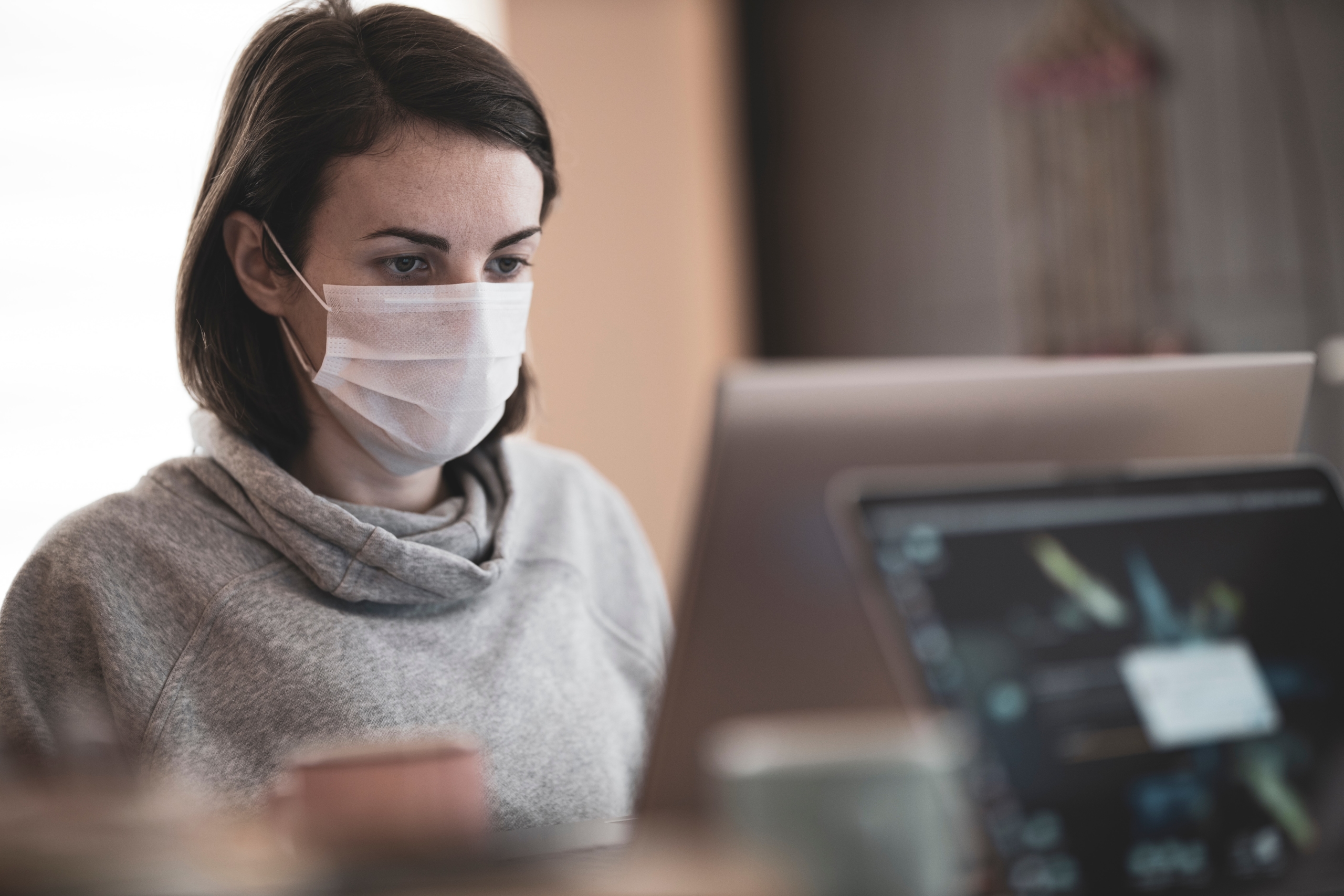 Woman in mask at computer